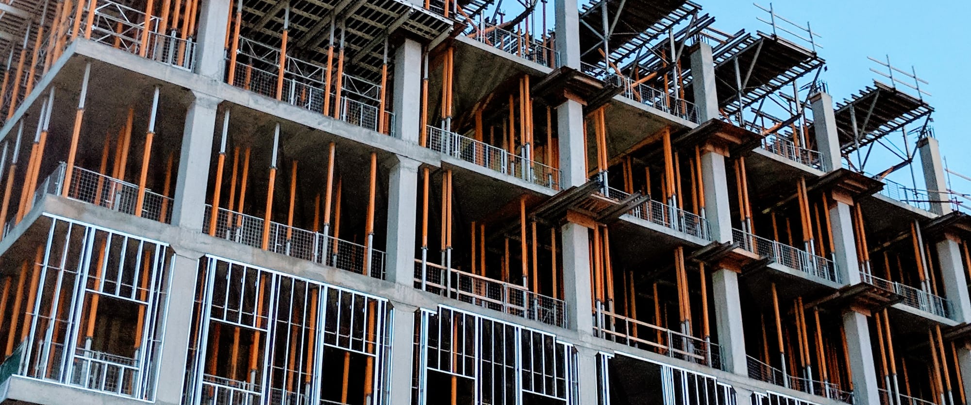 Staalconstructie van een gebouw in aanbouw, gezien vanaf de straat